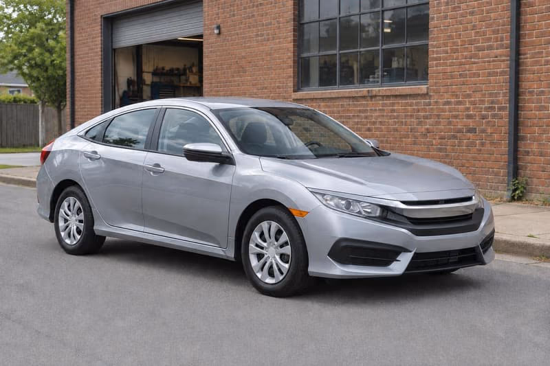 Eli’s car: a silver sedan parked outside a brick workshop